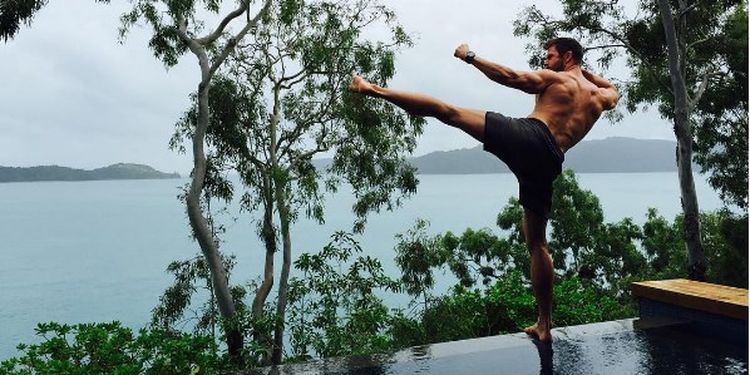 Workout addict Chris Hemsworth practicing kung-fu outdoors.