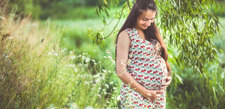 Photo of pregnant woman relaxing in nature