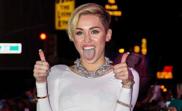 Photo of Miley Cyrus showing two thumbs up and tongue