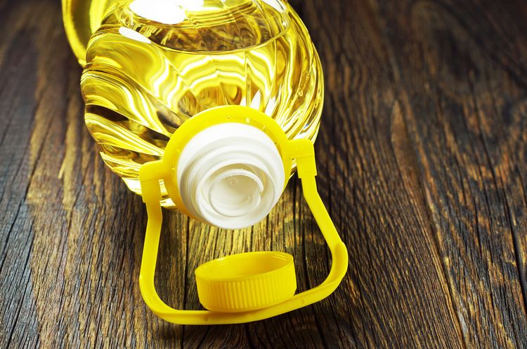 Photo of Canola Oil opened bottle lying on table