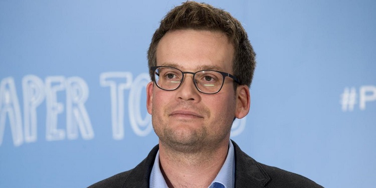 A photo of John Green with a blue background