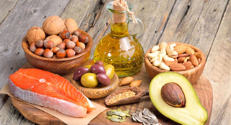 Selection of healthy fat sources on wooden background