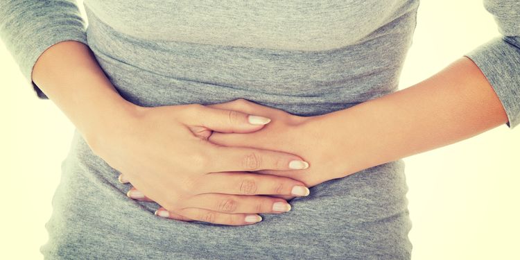 Photo of woman holding her stomach in pain