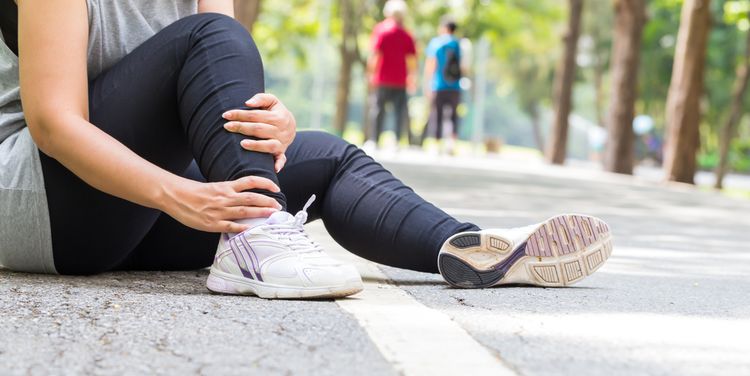 Photo of woman with pain in ankle while jogging