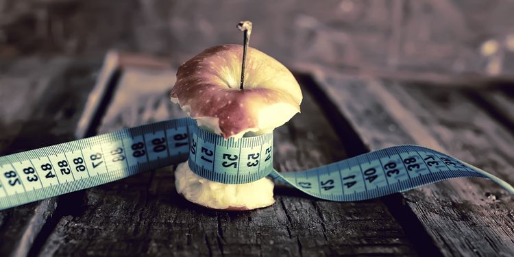 Photo of and eaten apple symbolizing weight loss