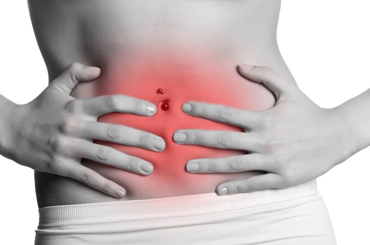 Photo of a woman holding her tummy in pain - Bloating