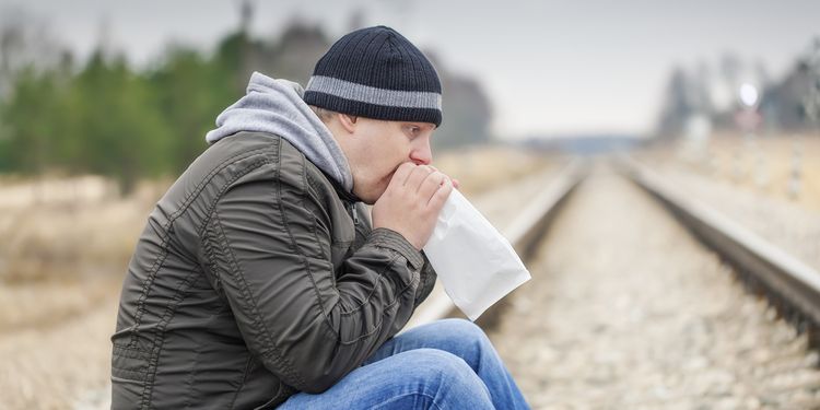 Photo of a man blowing in paper bag