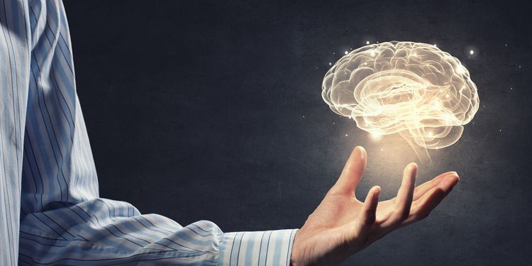 Photo illustration of a man holding 3D hologram of a brain 