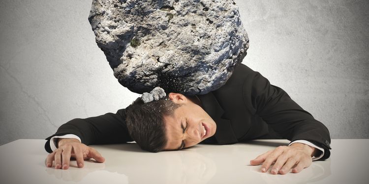 Photo of a businessman with large rock on his back