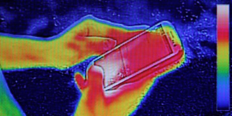 Infrared thermography image showing the heat emission when Young girl used smartphone