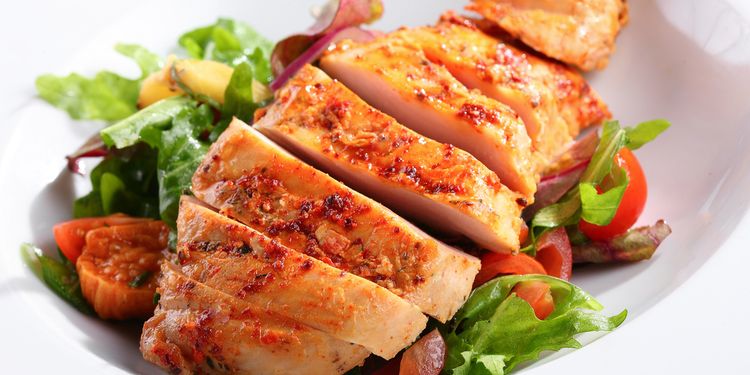 Photo of a grilled chicken breast with salad