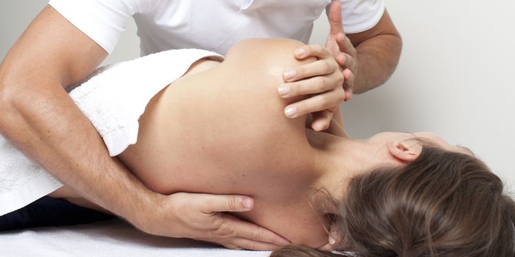 Photo of a chiropractor session working with young woman