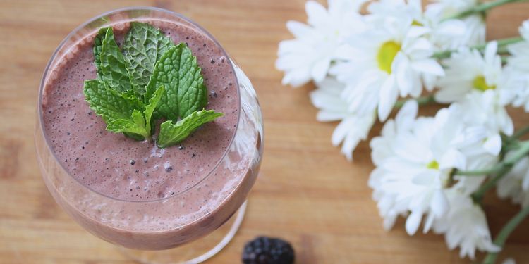 Photo of chocolate banana nut smoothie in a glass with mint leaves on top