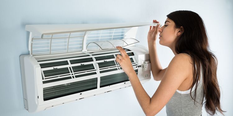 Photo of a woman cleaning dirty AC filter