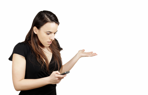 Photo of a woman holding her smartphone in confusion