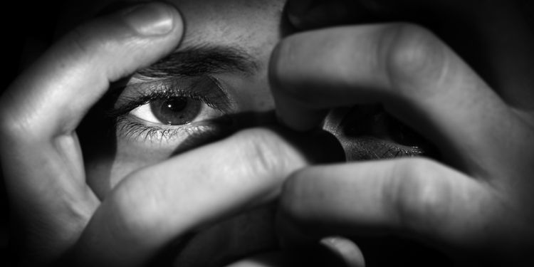 Photo of a woman showing her eye through her hands with an disturbing attitude