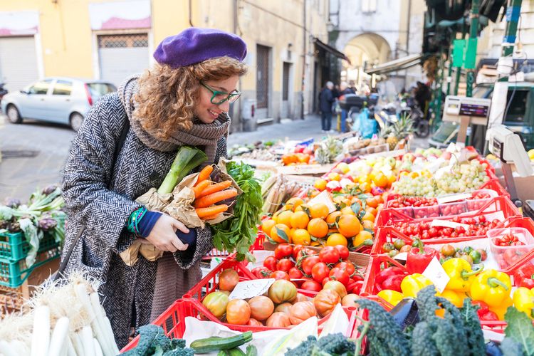 Photo of a woman buying vegetables at a Farmers' Market