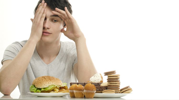 Photo of a man looking at the fast food rich in gluten that causes addiction