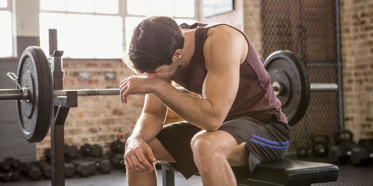 Photo of exhausted man in gym