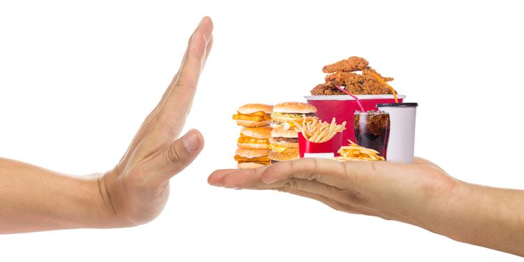 Photo of a hand holding on palm various junk foods and other hand refusing