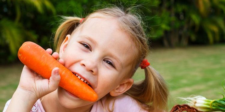 Photo of a kid eating a carrot