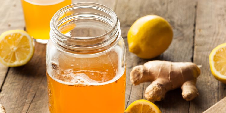 Photo of jar with kombucha tea and lemon and ginger next to it