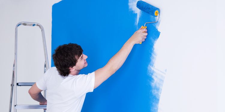 Photo of a man painting the wall