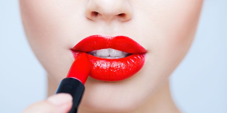 Photo of a woman using lipstick