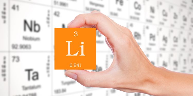 Photo of hand holding lithium element symbol