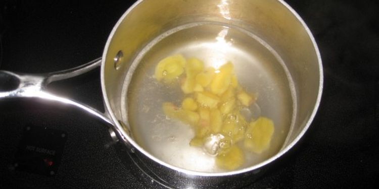 Photo of sliced ginger root cooking in water