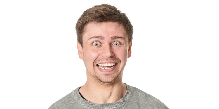 Photo of a young man with manic expression, on gray background