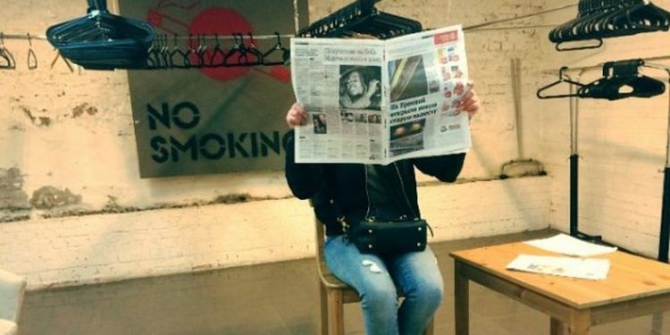 Image of a girl reading a newspaper