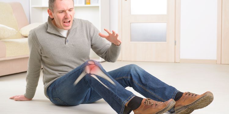 Photo of a man lying on floor with knee pain