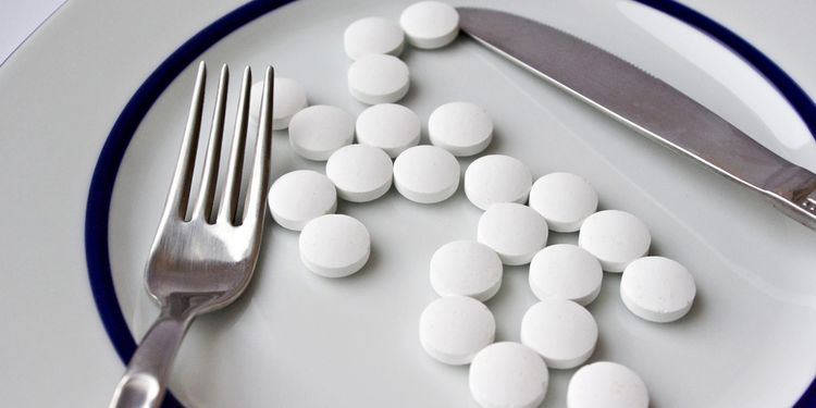 Photo of tablets on a plate with fork and knife