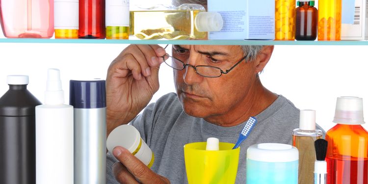 Unshaven Middle aged man reading a prescription label