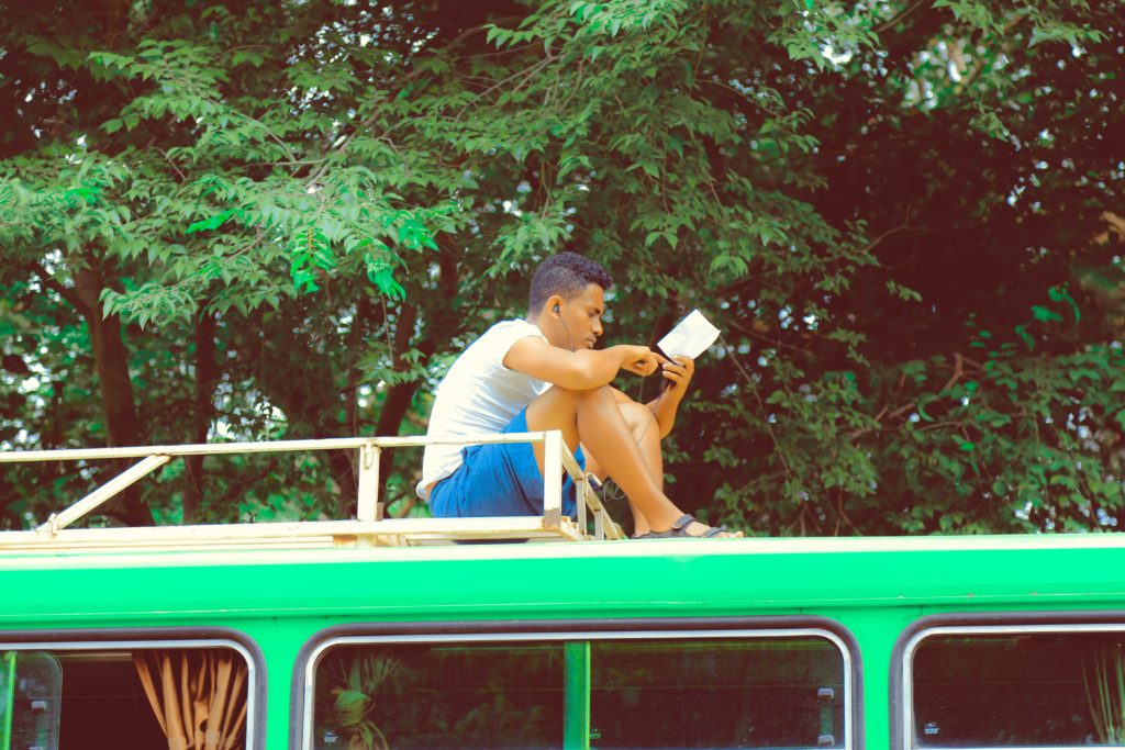 man reading notes on bus