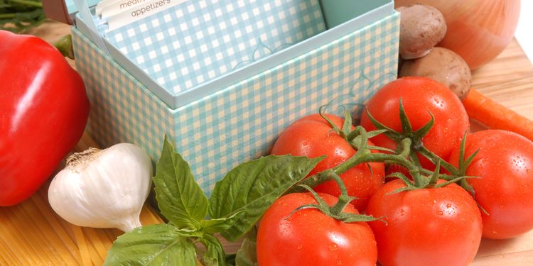 Photo of a box with recipes next to a fresh tomato