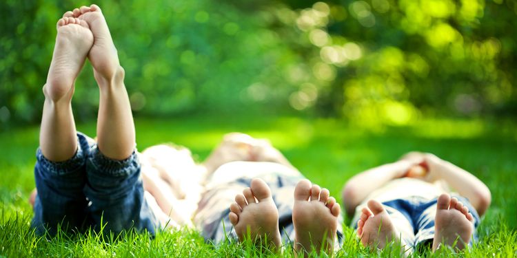 Photo of children lying in grass outdoors