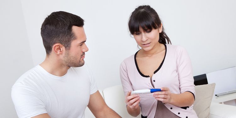 Photo of a young couple looking at a pregnancy test