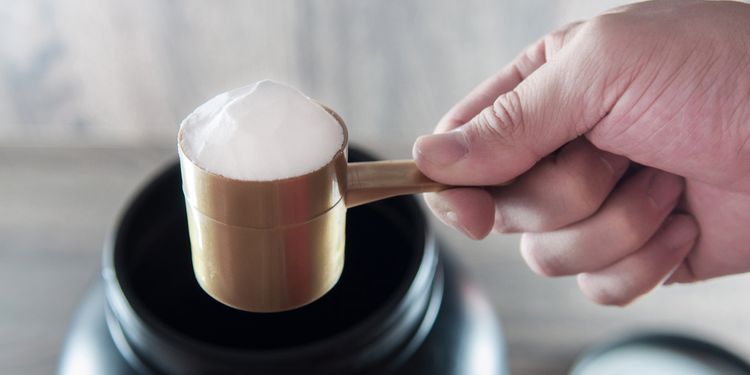 Photo of man holding scoop of glutamine