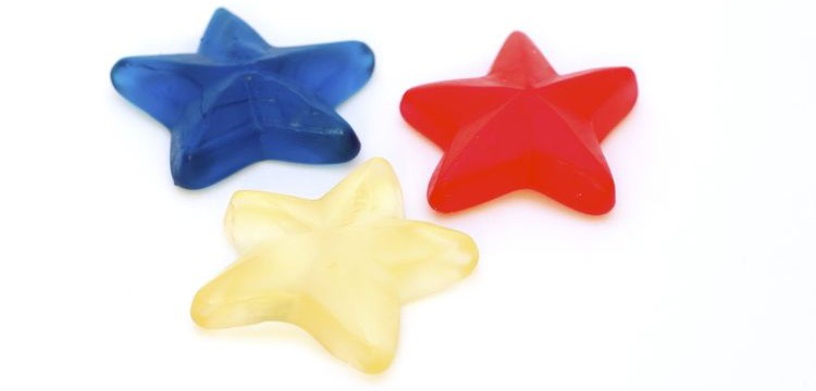 Photo of three star jelly candies on white background