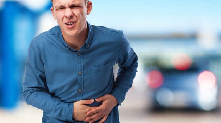 Photo of a man holding his stomach in pain