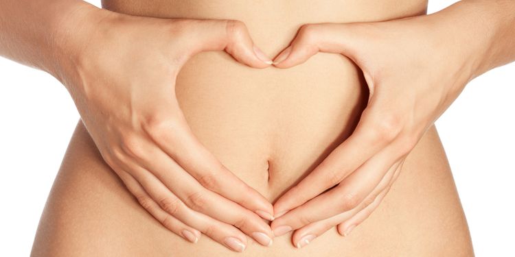 Photo of a female belly with heart sign made by hands