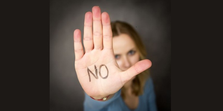 Photo of a woman showing her palm with word NO written on