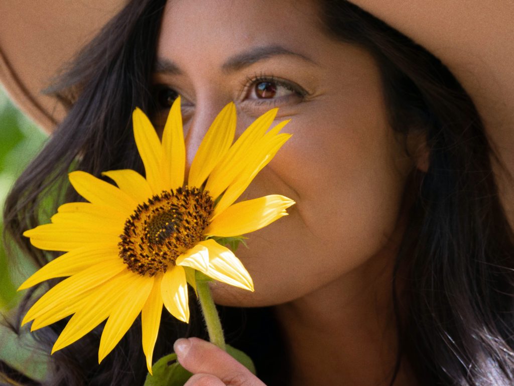 woman smelling sunflower