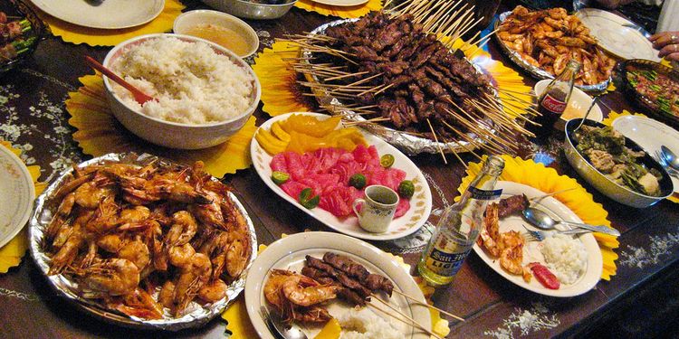 Photo of a dinning table with lots of food plates