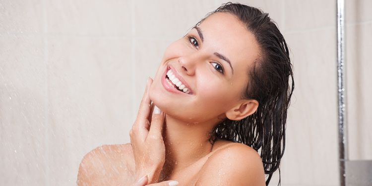 Photo of a woman under shower smiling