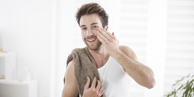 Photo of a man applying natural body wash on his face