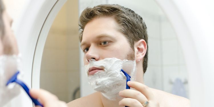 Photo of a man shaving his beard