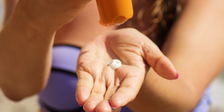 Photo of a person using sunscreen 